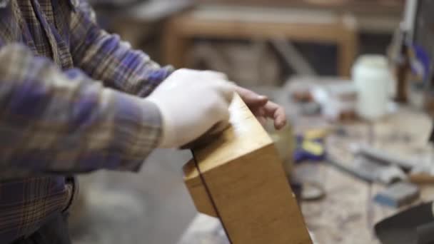 Nahaufnahme einer männlichen Hand, die einen hellen Holzständer mit einem Lappen reinigt — Stockvideo