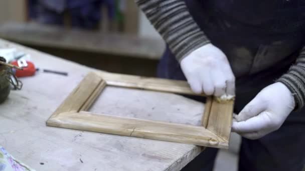 Male hands polishing cleaning wooden frame in woodcraft studio — Stock Video