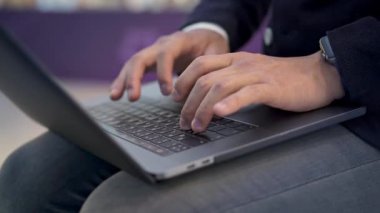 Gri dizüstü bilgisayarda akıllı saat yazarak erkek ellerinin çekimini kapatın
