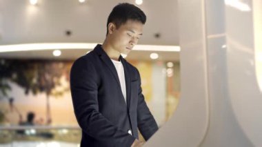 Genç Asya adam içinde Jacket ve shirt arama için bilgi içinde interaktif yönlendirme Kiosk