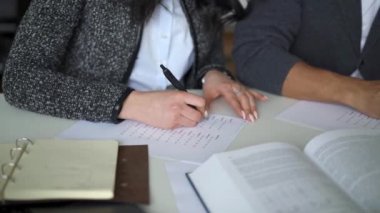 Çoktan seçmeli boşlukları dolduran kadın ve erkek ellerinin kapatılması
