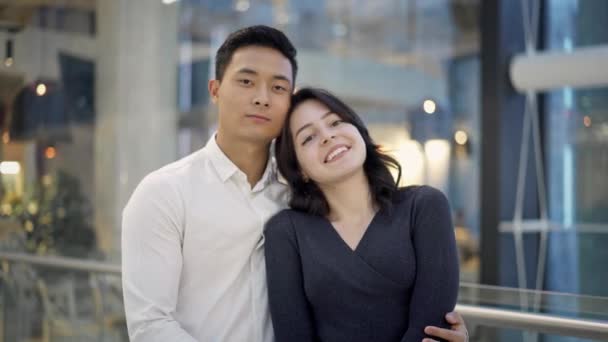 Retrato de pareja multiétnica abrazándose en el fondo del centro comercial — Vídeos de Stock