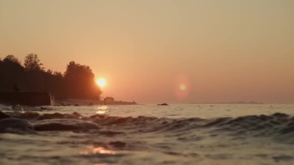 Primer plano de las olas del río al atardecer bajo el cielo anaranjado en verano — Vídeos de Stock