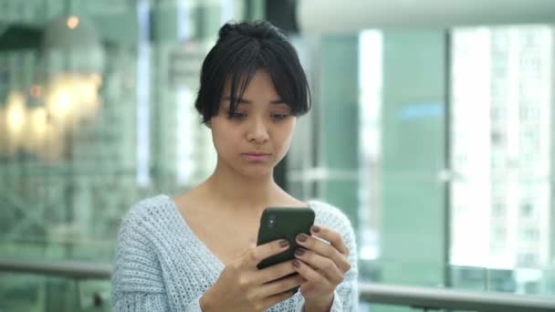 Porträtt Pan shot slow motion av allvarliga asiatiska kvinnliga stående skriva på telefon — Stockvideo