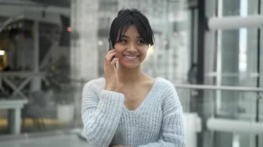 Telefonda konuşurken gülen asyalı kadın ayakta Orta çekim yavaş hareket