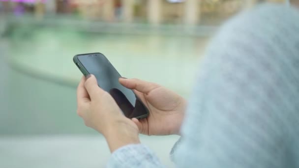 Mouvement lent portatif du téléphone à défilement féminin tout en marchant — Video