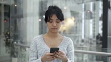 Windows arka planda bir telefon ile yürüyen Asyalı kadın Orta çekim