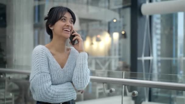 Μεσαία βολή της Ασίας θηλυκό γέλιο μιλάει στο τηλέφωνο, ενώ περπατάει — Αρχείο Βίντεο