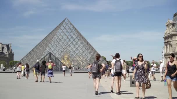 Paris-Haziran 17 2019: turistler bir çekim kuran gerçek zamanlı Louvre önünde yürümek. Louvre Müzesi dünyanın en çok ziyaret edilen sanat müzesinden biridir. — Stok video