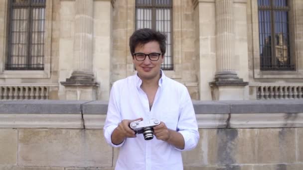 Joven alegre con el pelo oscuro en camisa tomando fotos. Retrato en cámara lenta . — Vídeos de Stock