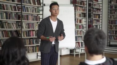 Genç Asya adam ile bir flipchart veren bir konferans içinde Library