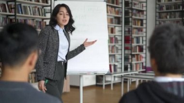 Genç Asya kadın ile bir flipchart veren bir konferans içinde Library