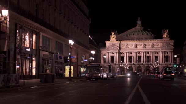 PARÍS, FRANCIA - 17 de junio de 2019: Panorama de izquierda a derecha en tiempo real con toma de Opera Garnier por la noche. La gente de la noche caminando y el tráfico en la calle . — Vídeos de Stock