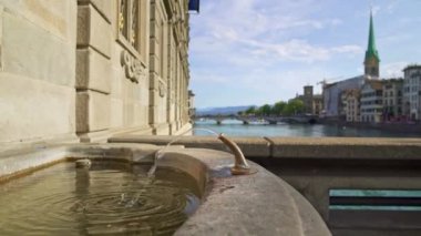 Zürih, Isviçre-Nisan 2019: Zürih ve Limmat arka planda su akışı ile eski Çeşme