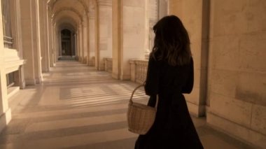 Paris, Fransa, Nisan 2019. Açık havada Louvre müzesi çalışan siyah elbiseli kadının yavaş hareket