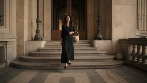 PARIS, FRANÇA, ABRIL 2019. Movimento lento de mulher em vestido preto andando ao ar livre Museu do Louvre — Vídeo de Stock