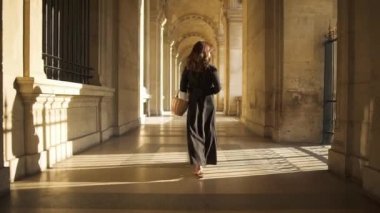Paris, Fransa, Nisan 2019. Louvre Müzesi açık havada yürüyen siyah elbiseli kadının yavaş hareket