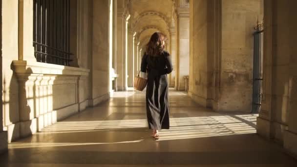 PARÍS, FRANCIA, ABRIL 2019. Movimiento lento de la mujer en vestido negro caminando al aire libre Museo del Louvre — Vídeo de stock