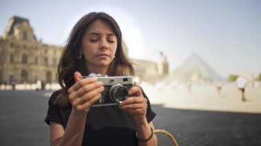 Paris, Fransa, Nisan 2019. Yavaş çekim genç kadın Louvre müzesinin arka planda bir film kamera ile fotoğraf yapma
