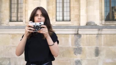 Paris, Fransa Güzel kadın bir film kamera ile fotoğraf yapma. Arka planda Paris'te eski binalar
