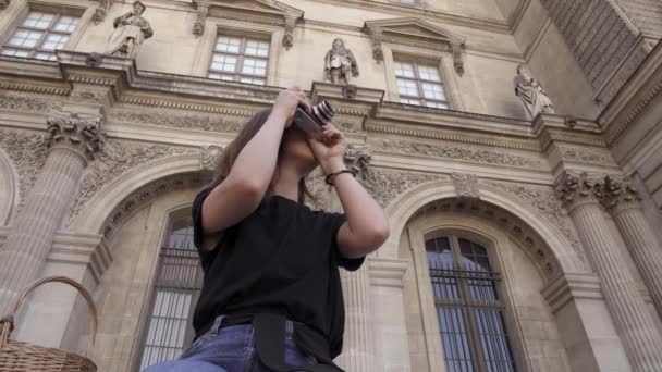 Belle jeune femme aux cheveux foncés, portant un jean et un t-shirt noir prend des photos de la ville. Portrait en temps réel . — Video