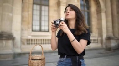Paris, güzel kadın arka planda bir film kamera ile fotoğraf yapma. Arka planda Paris'te eski binalar