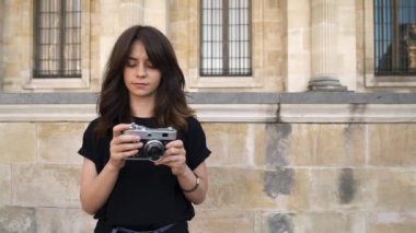 Güzel kadın arka planda bir film kamera geri sarma fotoğraf yapma. Arka planda Paris'te eski binalar