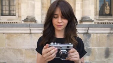 Eski Avrupa şehrinin arka planında bir film kamera geri sarma fotoğraf yapma genç kadın