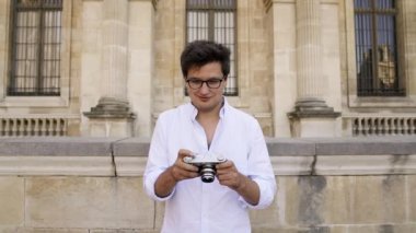 Paris mimarisinin bir resmini çeken beyaz gömlekyakışıklı freelancer