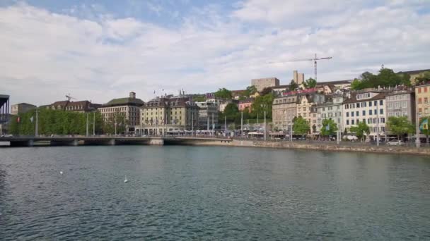 ZURICH, SWITZERLAND - APRIL 2019: Old houses on the waterfront and the bridge on the Limmat river — Stock Video