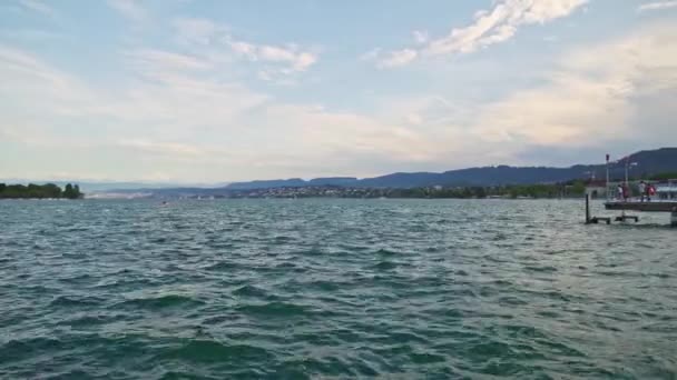 Pan tiro de lago de Zurique e cais com as pessoas no dia de verão — Vídeo de Stock