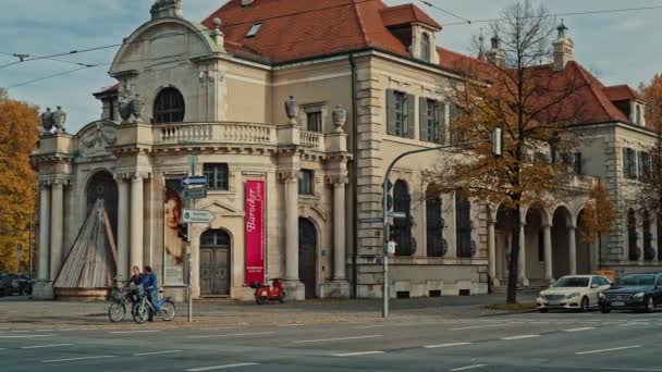 MUNICH, ALEMANIA - 20 de noviembre de 2019: De izquierda a derecha en tiempo real estableciendo la toma de Tráfico en una calle concurrida en Munich con el Museo Nacional de Baviera en el fondo, Munich, Alemania . — Vídeos de Stock