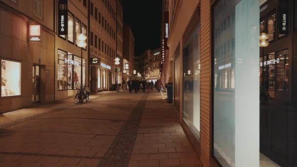 MUNICH, ALEMANHA - 26 de novembro de 2019: Fotografia em tempo real de pessoas andando no centro de Munique passando pela loja Windows à noite, Munique, Alemanha . — Vídeo de Stock