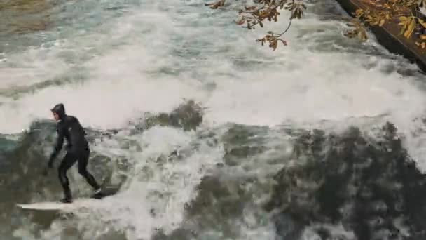 МЮНХЕН, ГЕРМАНИЯ, 18 ноября 2019 года: Снимок в реальном времени городских серферов на волне на реке Эйсбах. Речной серфинг в Английском саду Мунихса, Мюнхен, Германия . — стоковое видео
