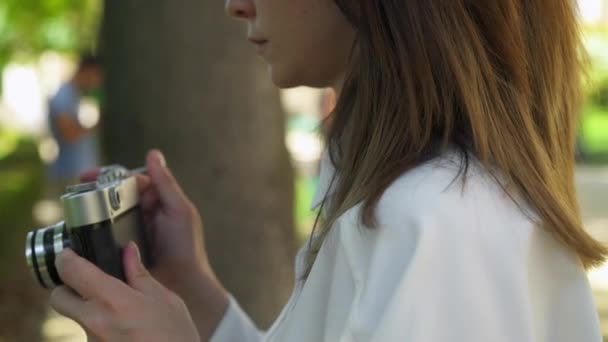 Perfil de una mujer caucásica haciendo una foto con una cámara de cine — Vídeos de Stock