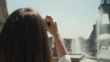 Eiffel Kulesi 'nin film kamerasıyla fotoğrafını çeken zarif kadının arkası.