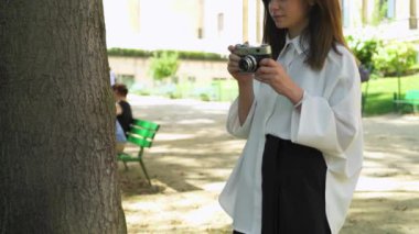 Kafkasyalı bir kadının film kamerasıyla fotoğraf çekerken ortası.