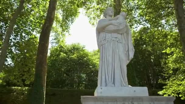 Pan tracking shot of statue in Versailles gardens alley in spring — Stock Video