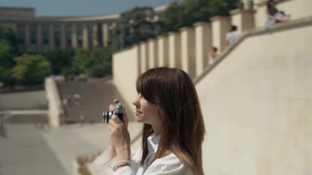 Kruhový snímek elegantní ženy, jak fotografuje Eiffelovku s filmovou kamerou
