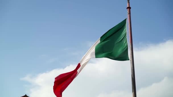 Italská vlajka vlající ve větru s modrou oblohou v pozadí. Zpomalený záběr — Stock video