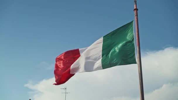 Italská vlajka vlající ve větru s modrou oblohou v pozadí. Reálný čas — Stock video