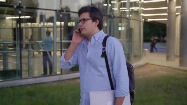 Plano medio del hombre en gafas y camisa azul haciendo una llamada — Vídeo de stock