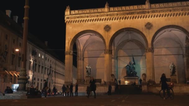 Mnichov, Německo - 26. listopadu 2019: Zleva doprava v reálném čase natáčí záběr Feldherrnhalle na Odeonsplatz v Mnichově v noci, Německo — Stock video