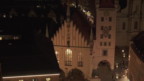 MUNICH, ALEMANHA - 26 de novembro de 2019: Incline-se em tempo real médio tiro da prefeitura velha em Marienplatz, em Munique, à noite. Marienplatz é a praça central de Munique . — Vídeo de Stock