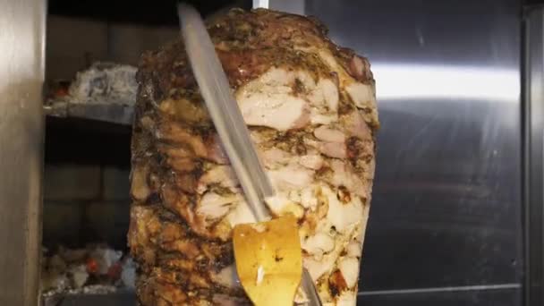 Cook slices chicken shawarma on a skewer to make doner kebab — Stock Video