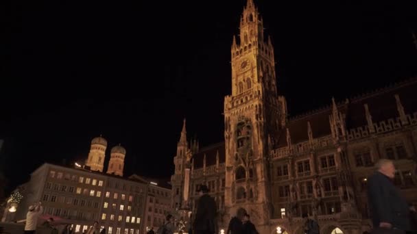 München, Németország - 2019. november 26.: Az Új Városháza éjszakai kilátása a Marienplatz-on Münchenben. Valós idejű felvétel, München, Németország. — Stock videók