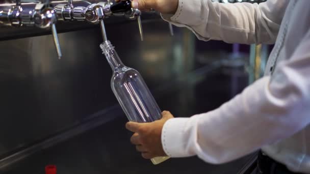 Un chupito mediano en tiempo real del camarero vierte cerveza en una botella de plástico — Vídeos de Stock