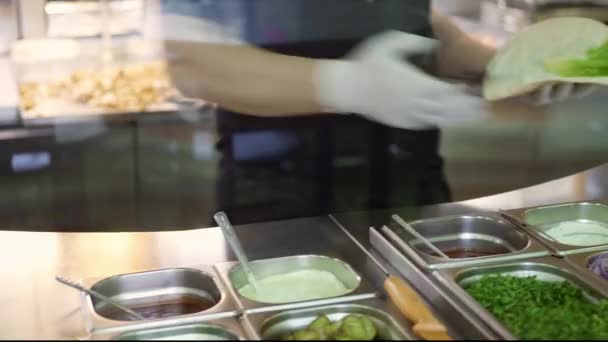 Χειροκίνητη λήψη των χεριών σεφ σε λευκά γάντια κάνοντας Doner σε pita — Αρχείο Βίντεο
