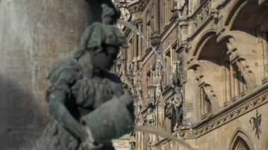 Münih 'teki Marienplatz' daki ünlü balık çeşmesinde gerçek zamanlı bir erkek figürü..