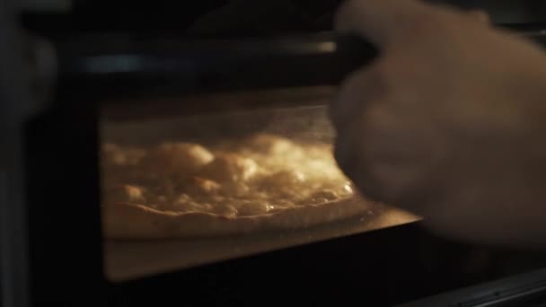 Handheld close-up van kaas pizza bakken in de oven — Stockvideo
